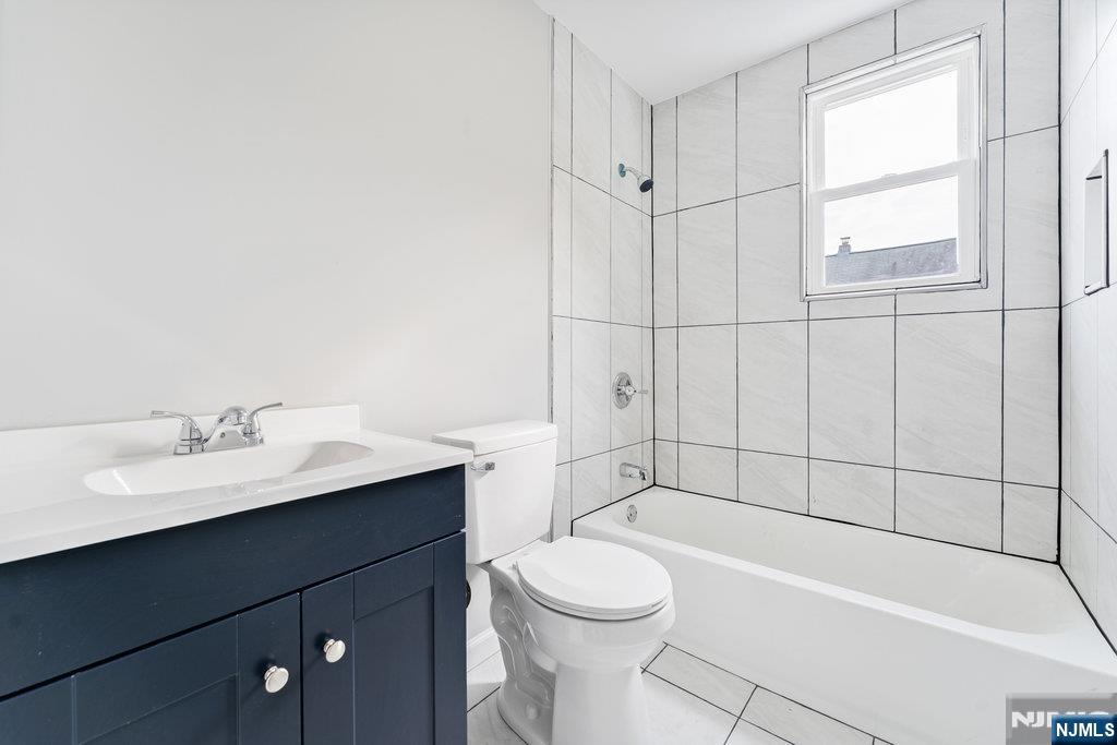 16 John Street, Unit 2 Lodi, NJ 07644 - Photo 18 of 32 a bathroom with a sink a toilet and shower