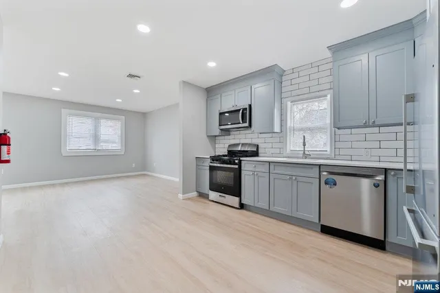 a kitchen with granite countertop white cabinets and stainless steel appliances
