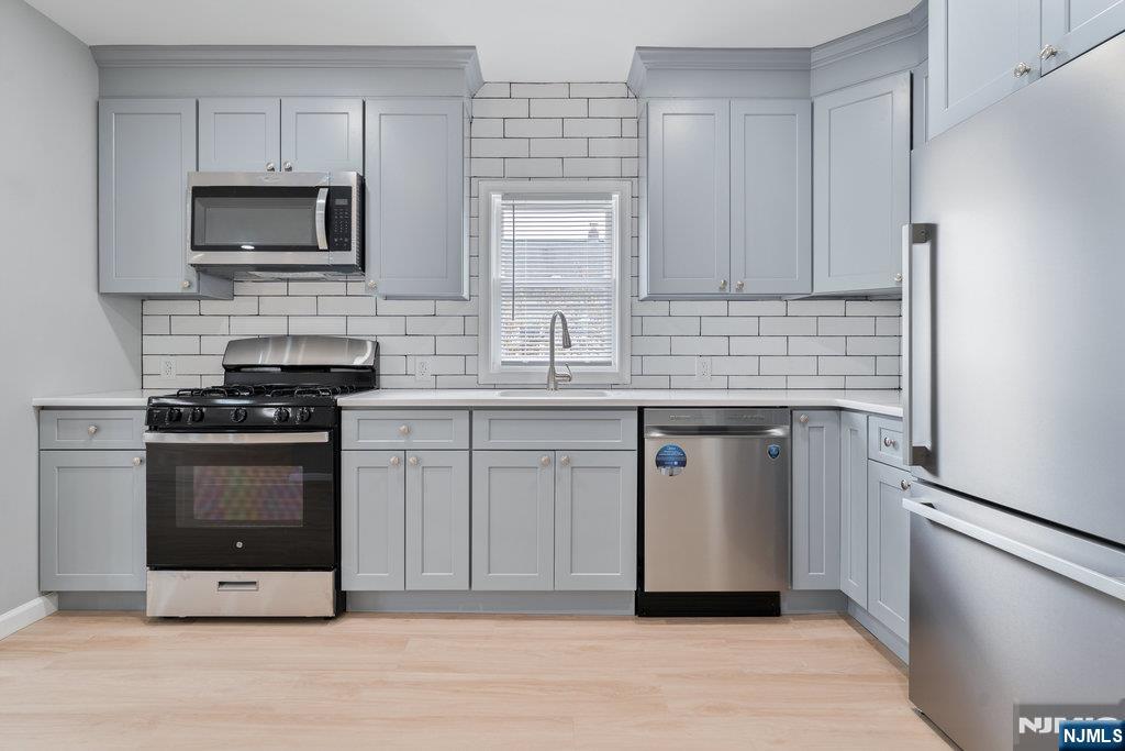 16 John Street, Unit 2 Lodi, NJ 07644 - Photo 24 of 32 a kitchen with stainless steel appliances a stove microwave and sink