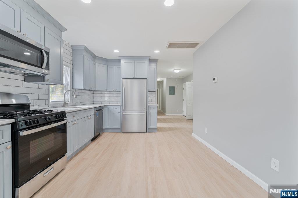 16 John Street, Unit 2 Lodi, NJ 07644 - Photo 25 of 32 a kitchen with white cabinets and stainless steel appliances