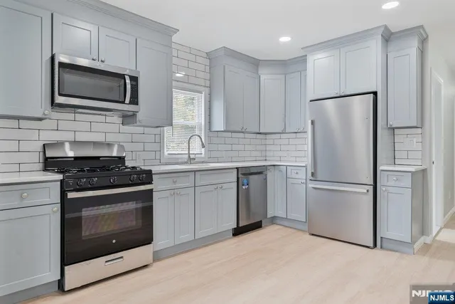 a kitchen with cabinets stainless steel appliances and a counter space