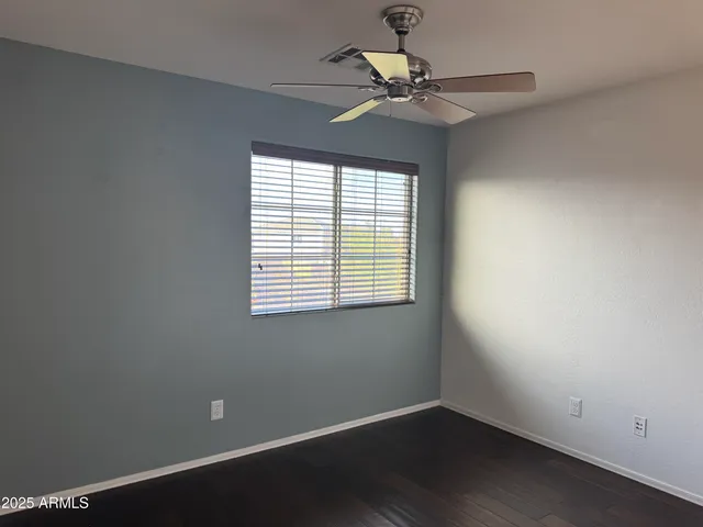 an empty room with a window and a fan