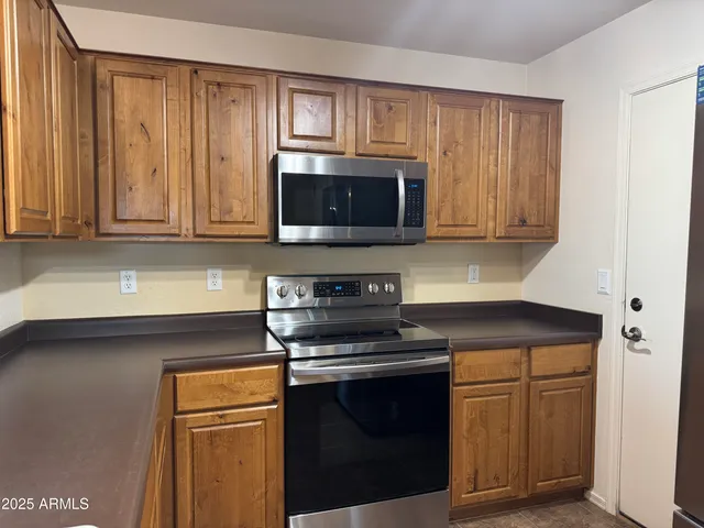 a kitchen with stainless steel appliances granite countertop a stove microwave and sink