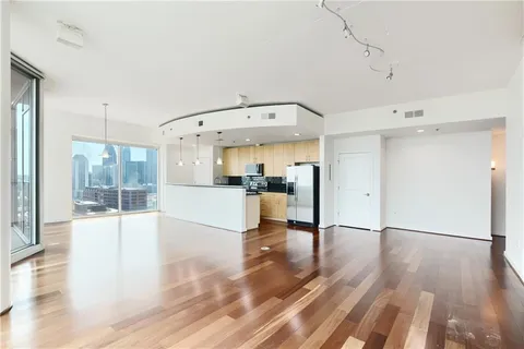 a open kitchen with white cabinets and wooden floors