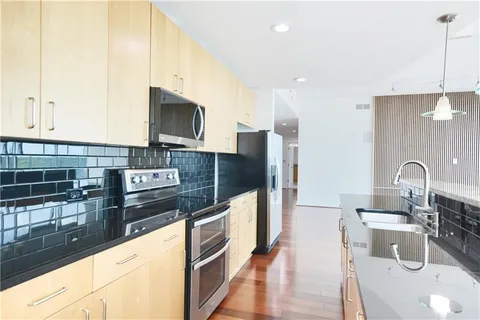 a kitchen with stainless steel appliances granite countertop a sink and a stove