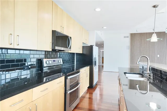 a kitchen with stainless steel appliances granite countertop a sink and a stove