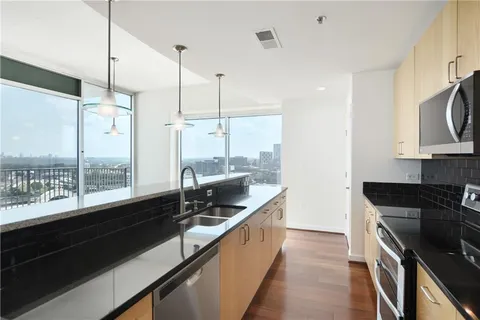 a kitchen with a large window and stainless steel appliances