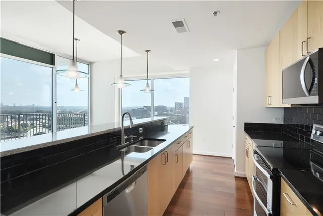 a kitchen with a large window and stainless steel appliances