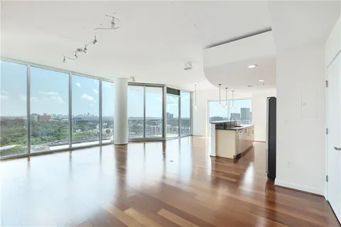 a view of empty room with wooden floor and floor to ceiling window