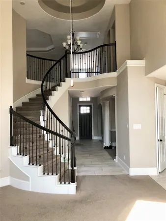 a view of staircase with railing and white walls