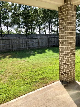 a view of a yard with wooden fence