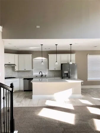 a large kitchen with stainless steel appliances kitchen island granite countertop a sink and cabinets