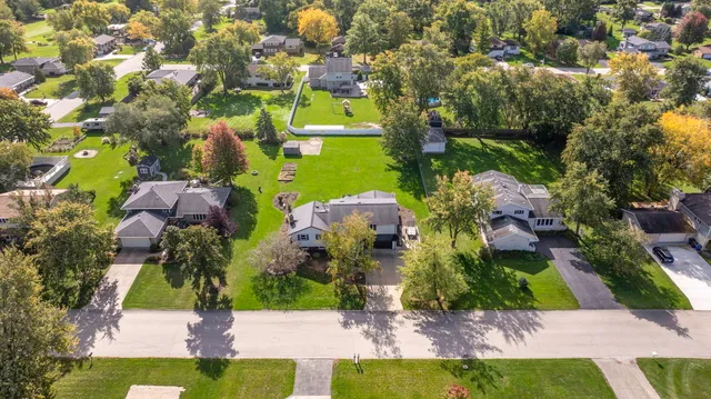 an aerial view of residential houses with outdoor space and trees