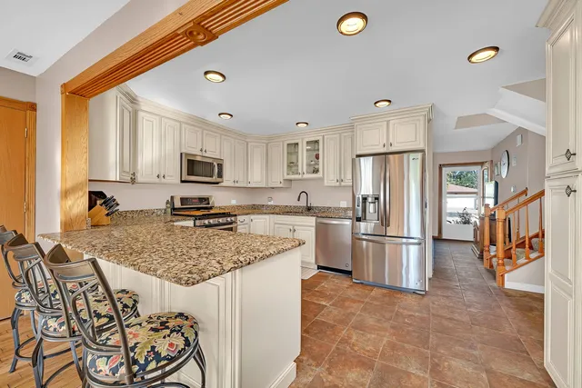 a kitchen with stainless steel appliances granite countertop a sink stove and refrigerator
