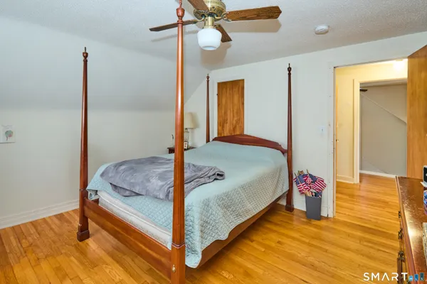 a bedroom with a bed and wooden floor