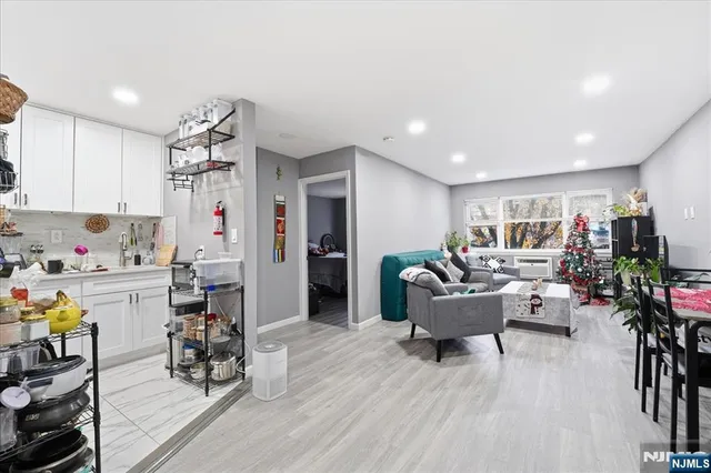a living room with furniture and a dining table with wooden floor