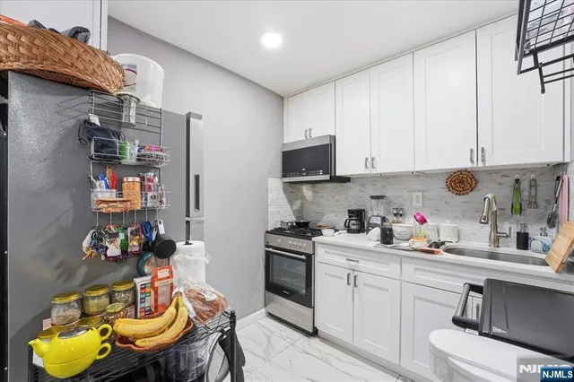 a kitchen with a white cabinets and appliances