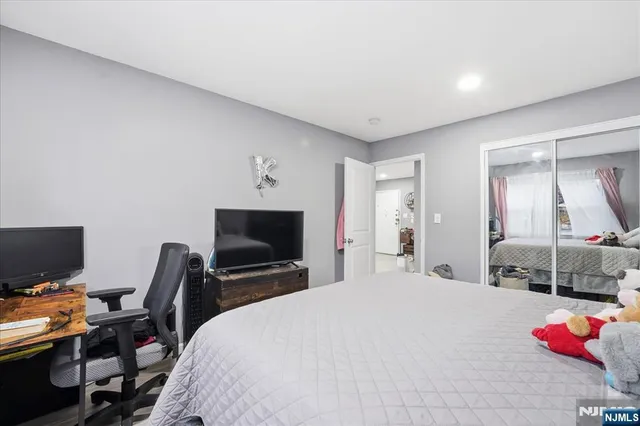 a bedroom with a bed and a flat screen tv