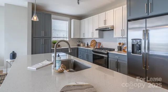a kitchen with stainless steel appliances granite countertop a sink stove and refrigerator