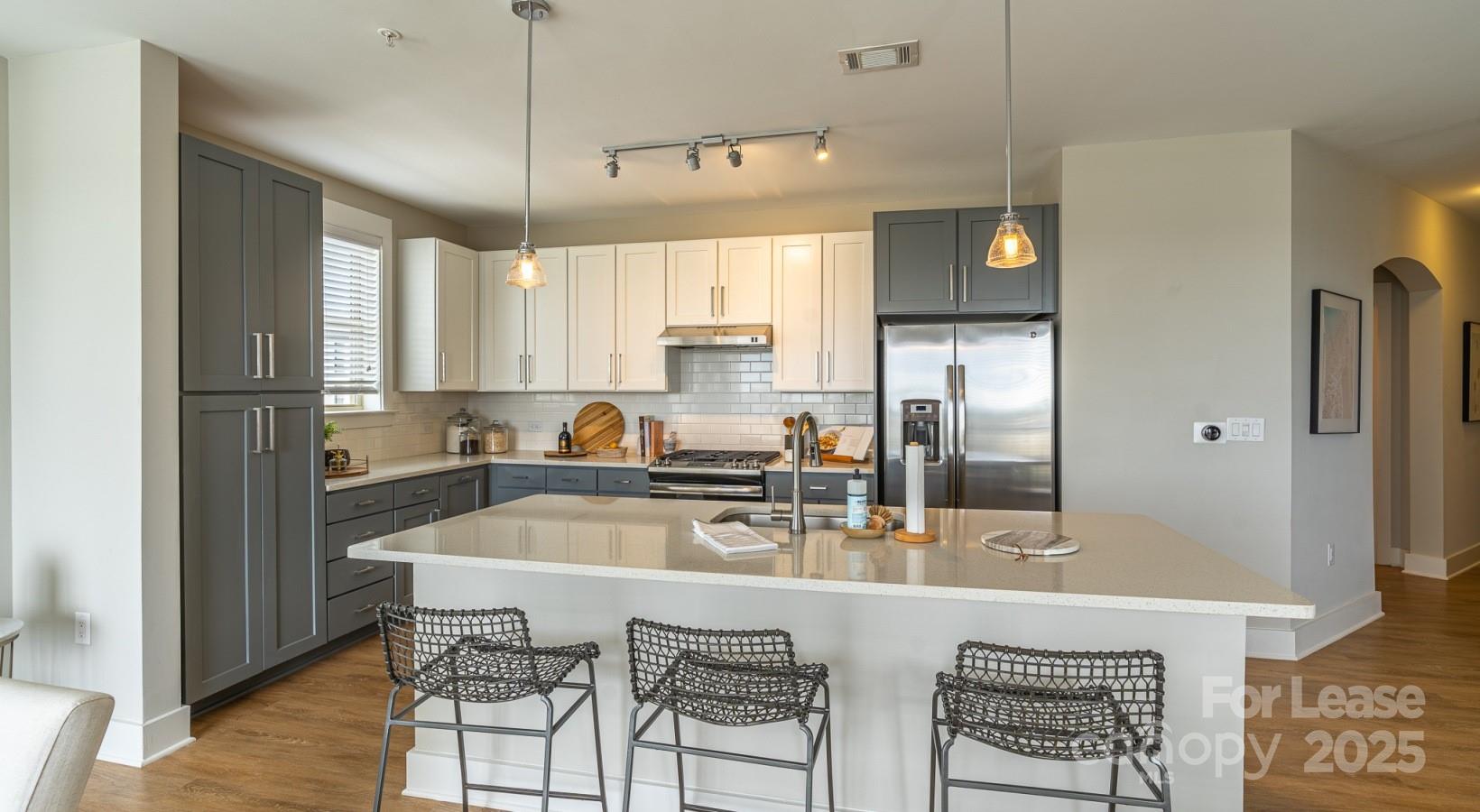 6408 Providence Farm Lane, Unit B2 Charlotte, NC 28277 - Photo 33 of 44 a kitchen with granite countertop a refrigerator a stove a sink and white cabinets with wooden floor