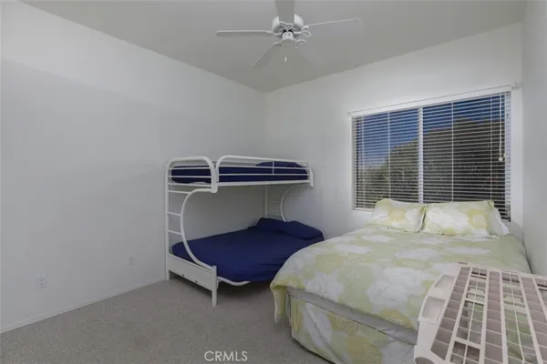a bedroom with a bed and a ceiling fan