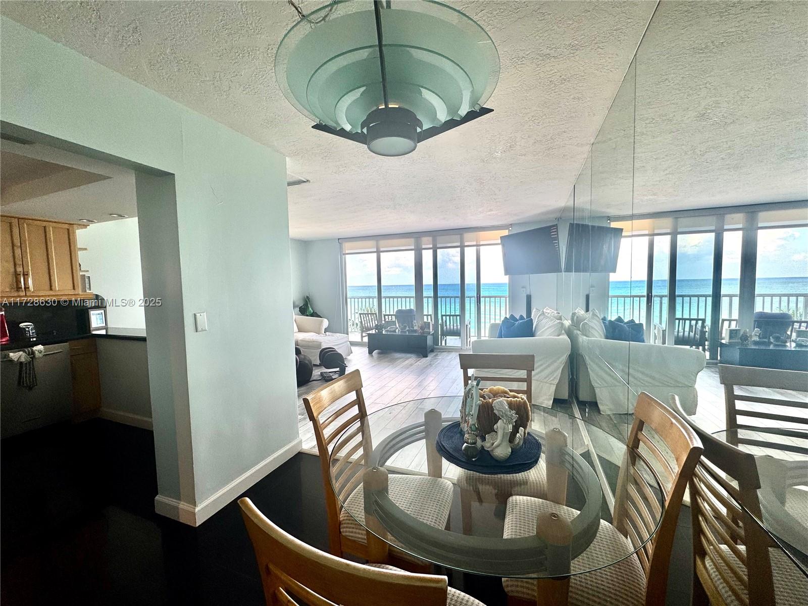 400 North Surf Road, Unit 701 Hollywood, FL 33019 - Photo 2 of 26 a living room with furniture and a chandelier