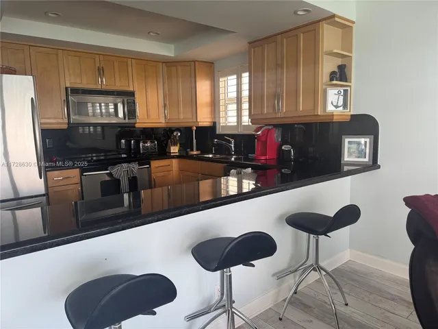 a kitchen with stainless steel appliances granite countertop a stove a sink and a refrigerator