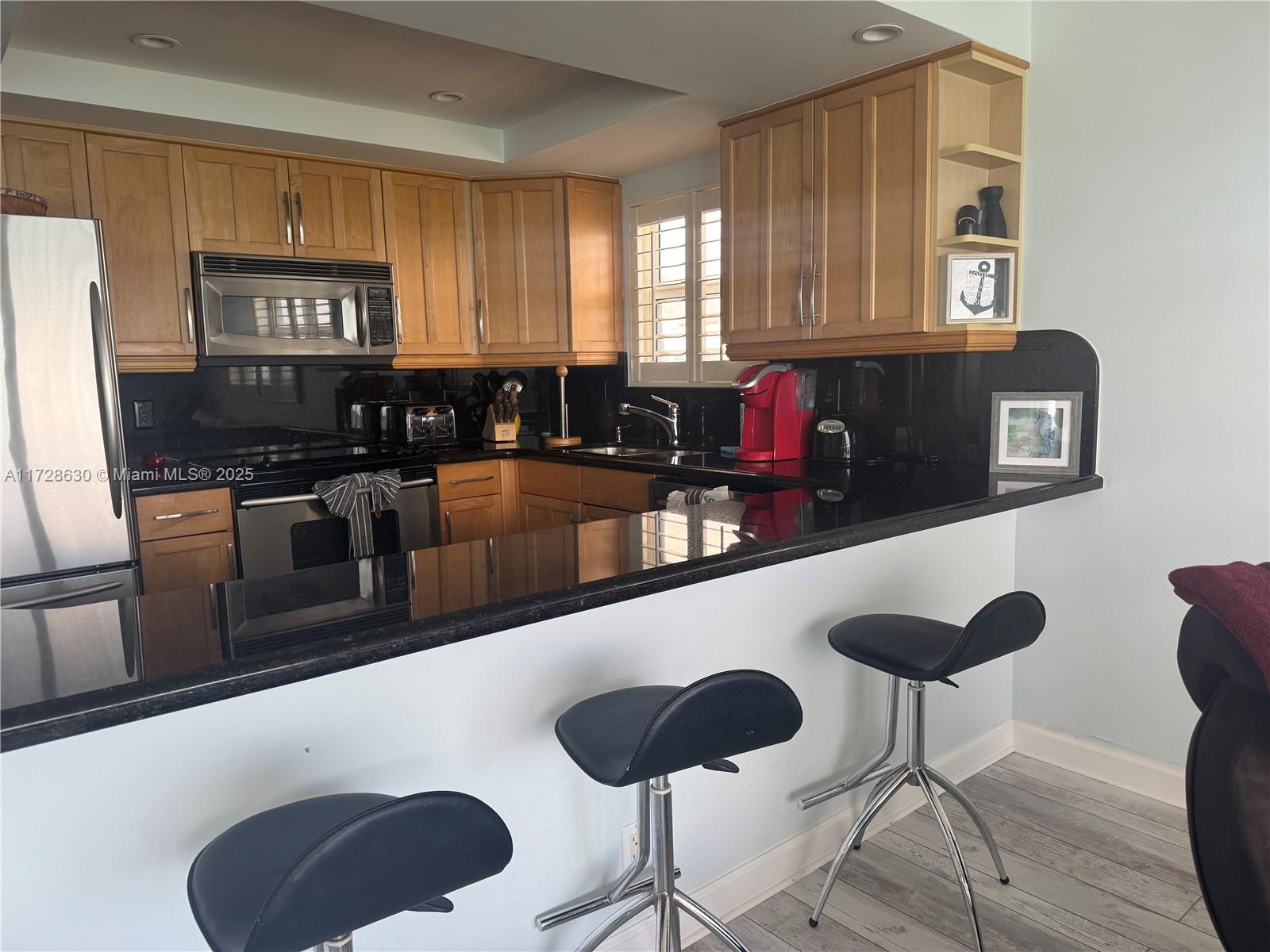 400 North Surf Road, Unit 701 Hollywood, FL 33019 - Photo 5 of 26 a kitchen with stainless steel appliances granite countertop a stove a sink and a refrigerator