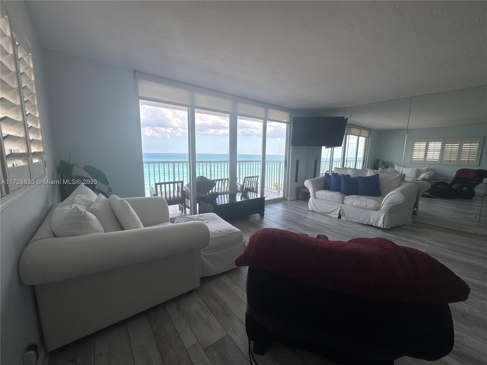 400 North Surf Road, Unit 701 Hollywood, FL 33019 - Photo 8 of 26 a living room with furniture and a floor to ceiling window