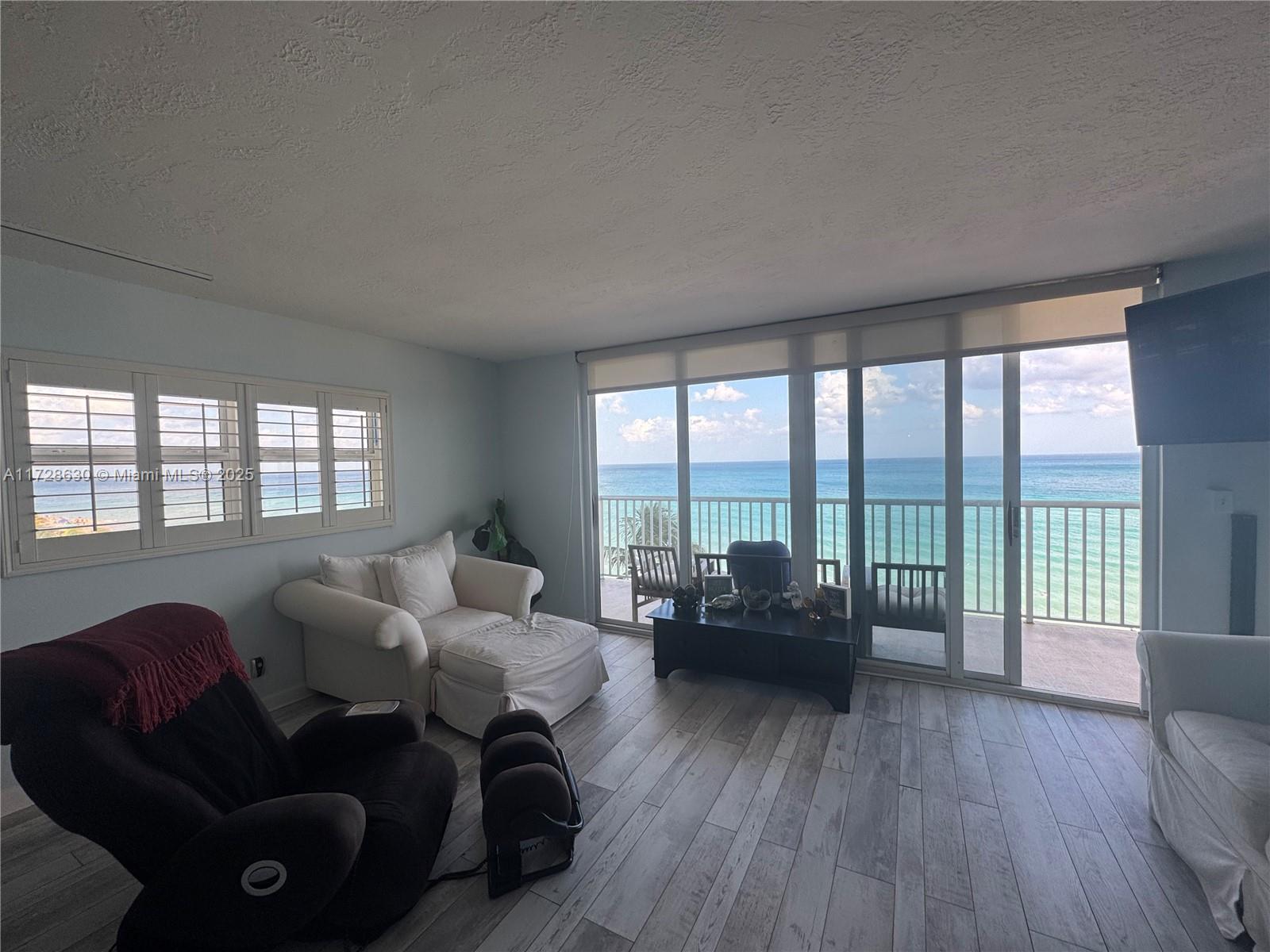 400 North Surf Road, Unit 701 Hollywood, FL 33019 - Photo 9 of 26 a living room with furniture and a large window with wooden floor