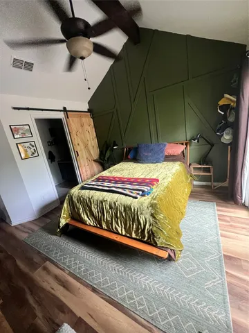a bedroom with a bed and wooden floor