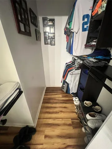 a view of walk in closet with clothes and shoes