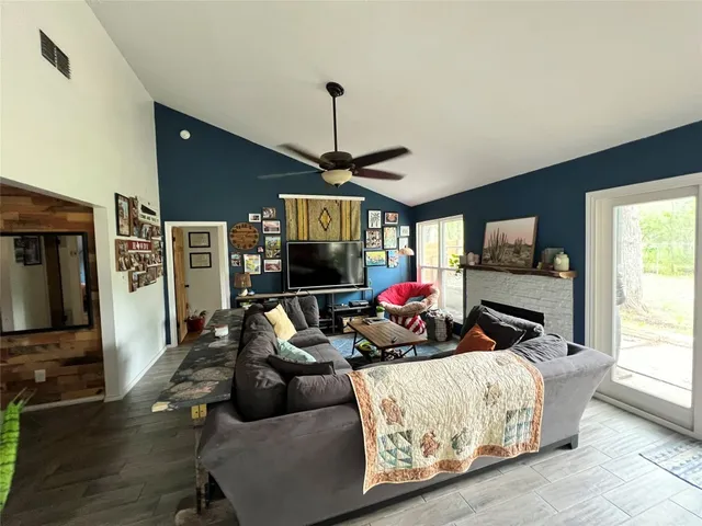 a living room with furniture a flat screen tv and a window