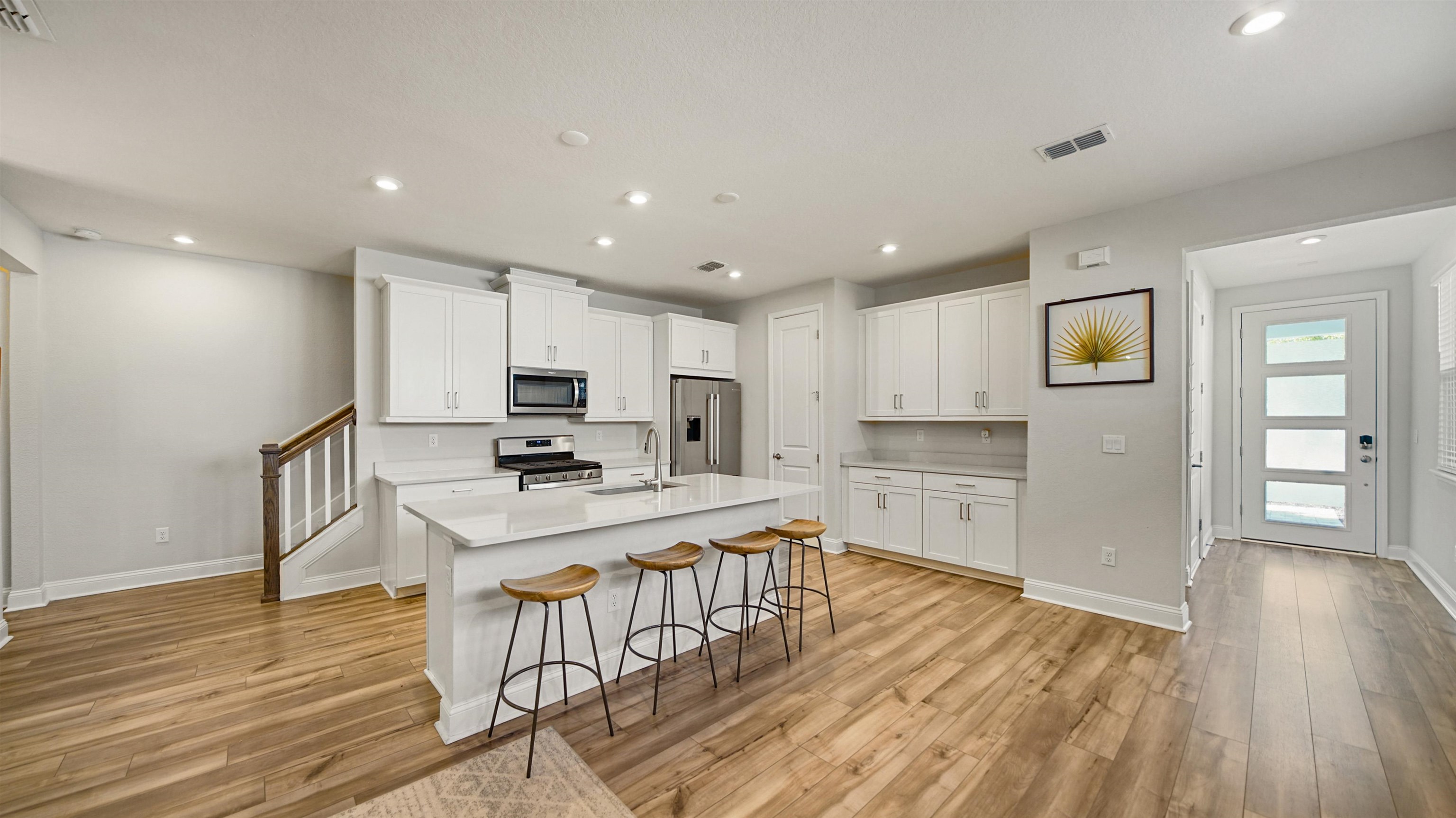 14141 Backbarrier Road Jacksonville, FL 32224 - Photo 3 of 45 a kitchen with stainless steel appliances granite countertop a refrigerator oven stove a island and white cabinets with wooden floor