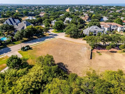an aerial view of residential houses with outdoor space and trees