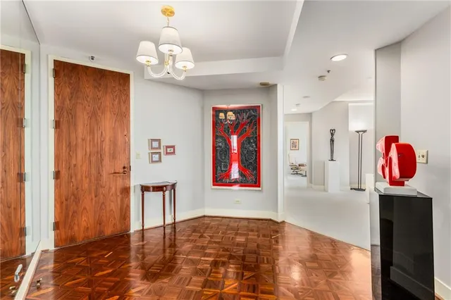 a view of a hallway with a dining table and chandelier