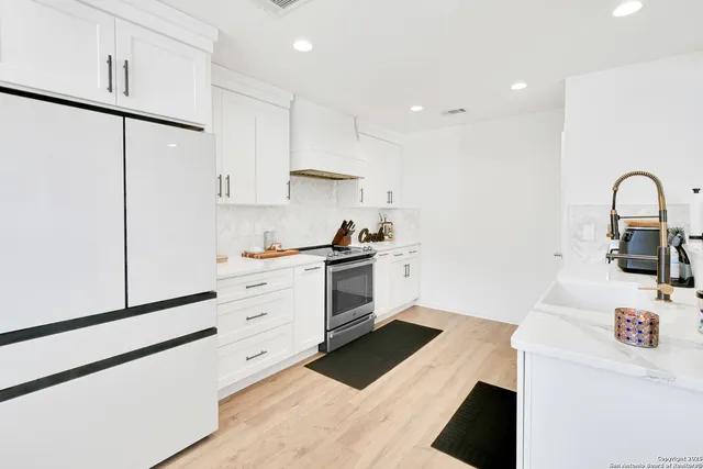 a kitchen with granite countertop white cabinets and white appliances