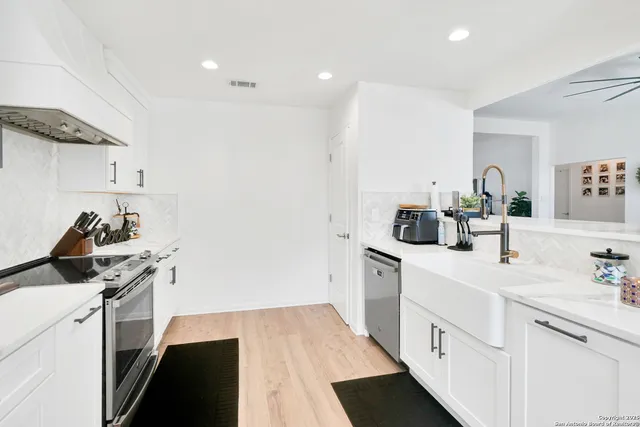a kitchen with a sink stove and white cabinets