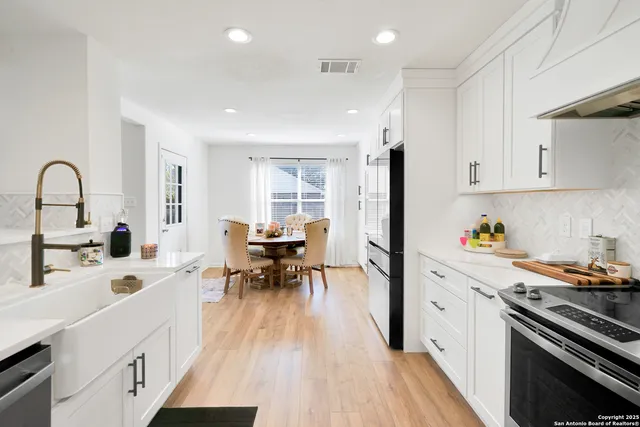 a kitchen with granite countertop a sink stove and cabinets