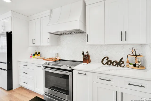 a kitchen with white cabinets and appliances