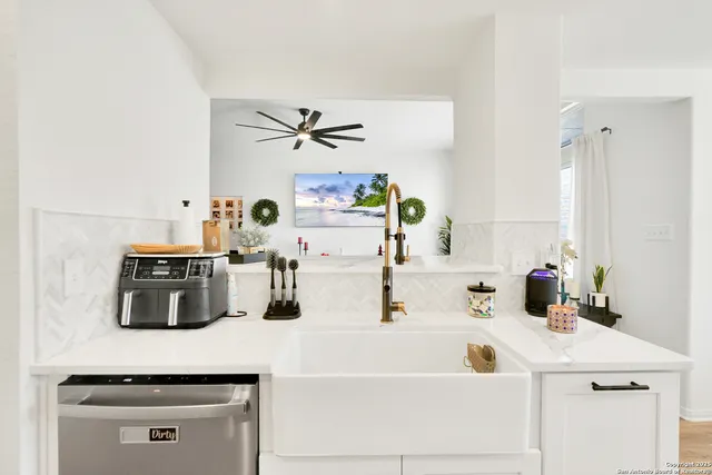 a kitchen with kitchen island a sink a stove and white cabinets