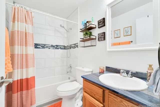 a bathroom with a granite countertop sink mirror vanity and toilet