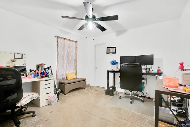 a view of a workspace with furniture and a window