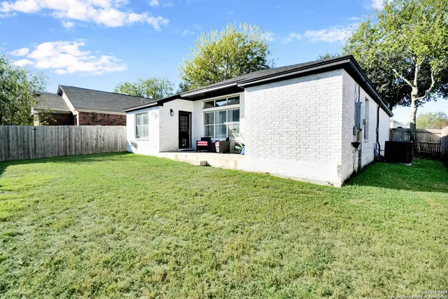 a view of a backyard with potted plants and large tree