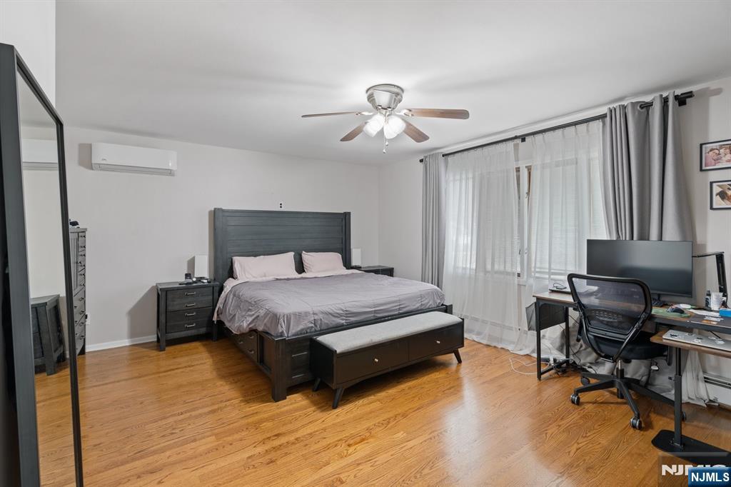 74 Kipp Avenue Hasbrouck Heights, NJ 07604 - Photo 12 of 28 a bedroom with a bed a desk and chair with wooden floor