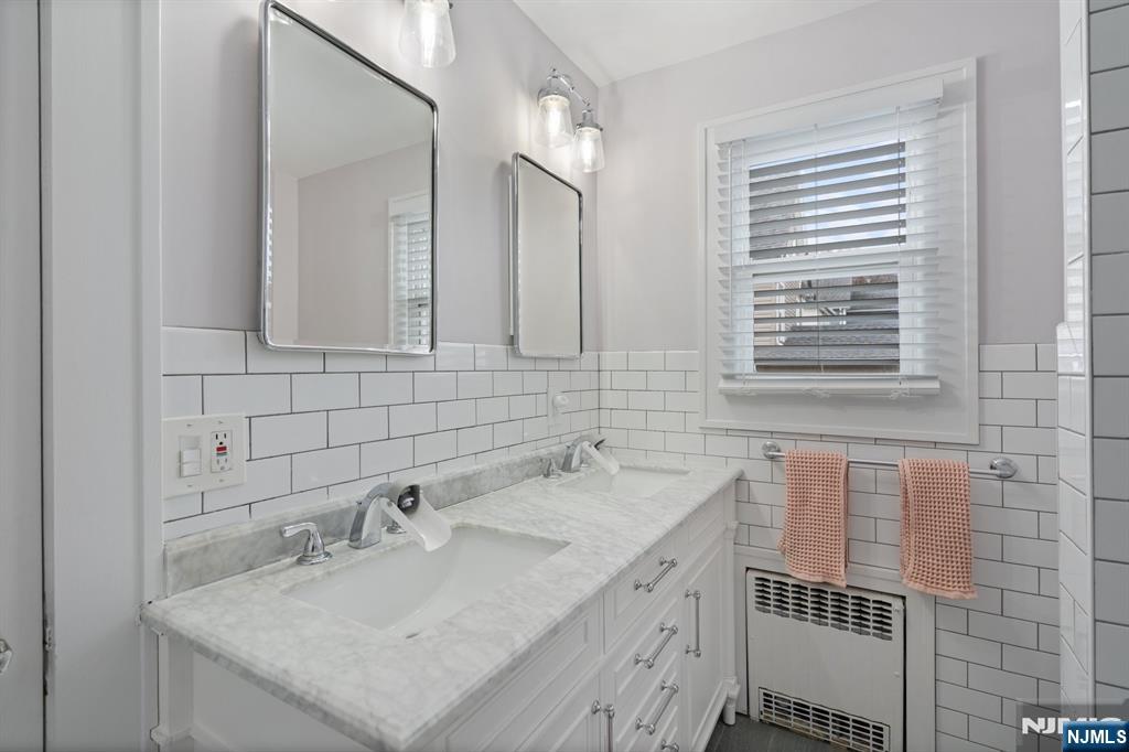 74 Kipp Avenue Hasbrouck Heights, NJ 07604 - Photo 20 of 28 a bathroom with a sink a vanity and a mirror