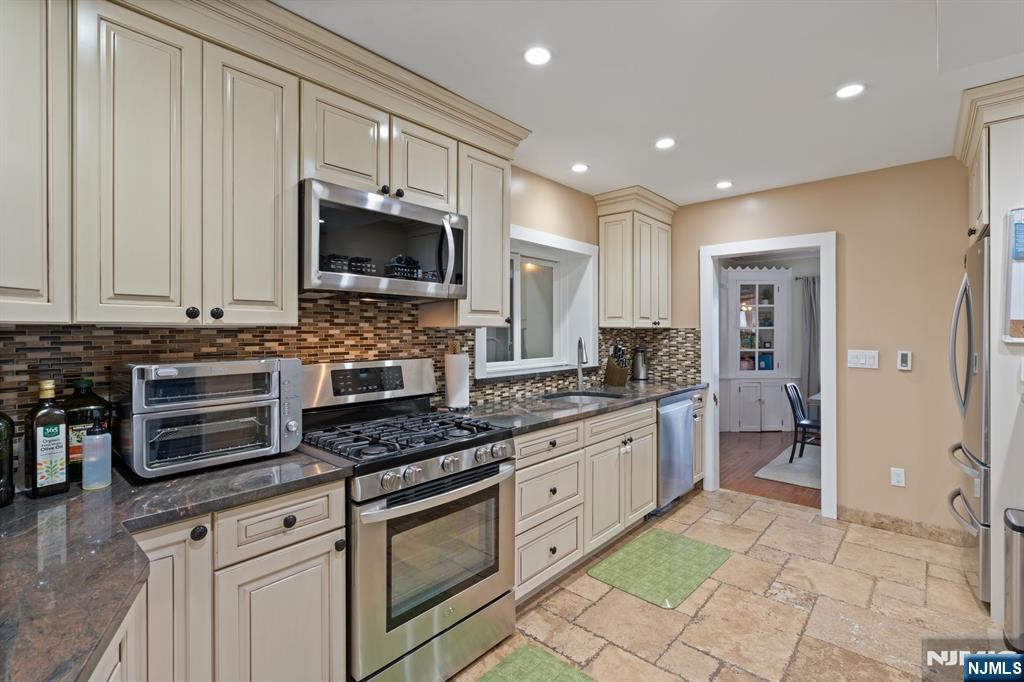 74 Kipp Avenue Hasbrouck Heights, NJ 07604 - Photo 5 of 28 a kitchen with stainless steel appliances granite countertop a stove and a sink