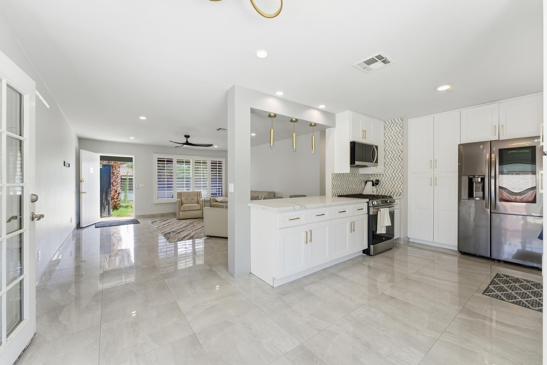 40961 Cecina Way Bermuda Dunes, CA 92203 - Photo 9 of 27 a large white kitchen with a refrigerator a stove a sink and a cabinets