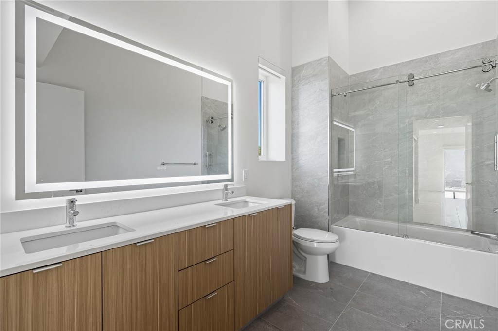 12078 Guerin Street, Unit 406 Studio City, CA 91604 - Photo 11 of 16 a bathroom with a sink a toilet a mirror and shower