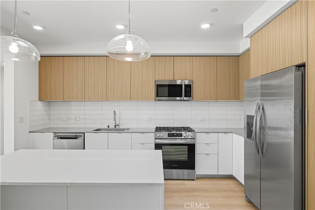 12078 Guerin Street, Unit 406 Studio City, CA 91604 - Photo 4 of 16 a kitchen with kitchen island stainless steel appliances a sink cabinets and a counter top space